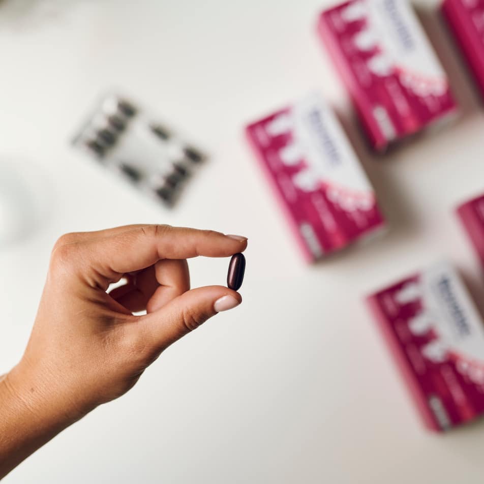 Roka, ki drži kapsulo Novalac z aktivno folno kislino Quatrefolic.